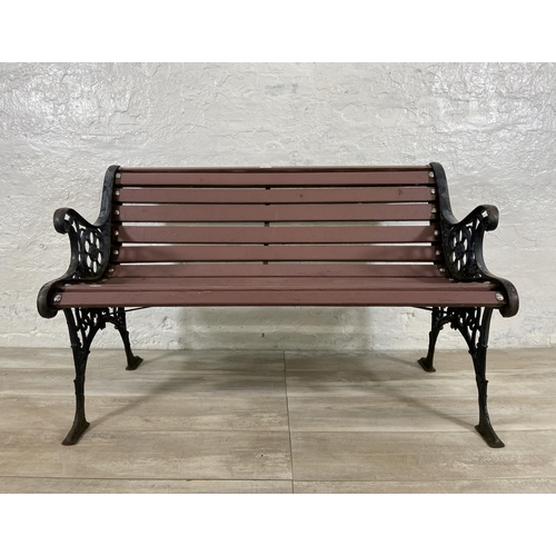 69 - A cast iron and wooden slatted two seater garden bench - approx. 72cm high x 110cm wide x 58cm deep