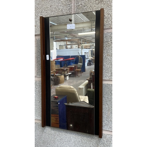 7 - A mid 20th century teak and ebonised framed wall mirror - approx. 56cm high x 31cm wide