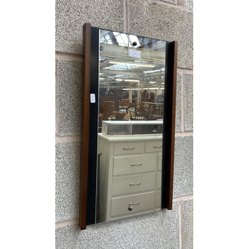 7 - A mid 20th century teak and ebonised framed wall mirror - approx. 56cm high x 31cm wide