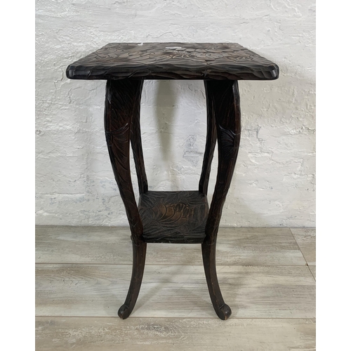 21 - An Arts & Crafts Liberty & Co. Japanese hand carved wooden two tier side table - approx. 70cm high x... 