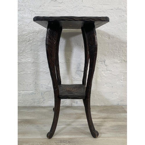 21 - An Arts & Crafts Liberty & Co. Japanese hand carved wooden two tier side table - approx. 70cm high x... 