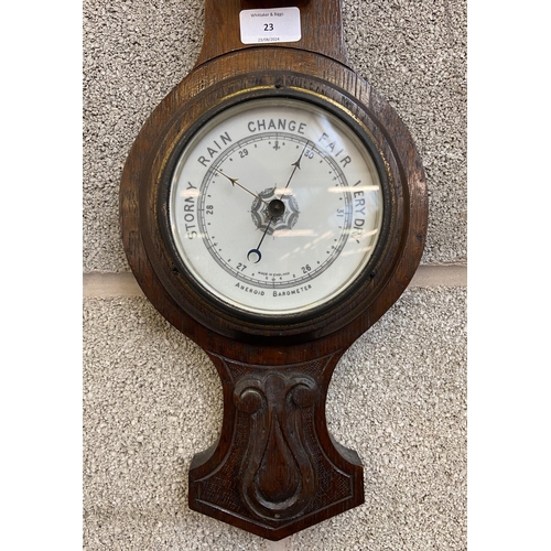 23 - A late 19th century carved oak aneroid barometer - approx. 66cm high