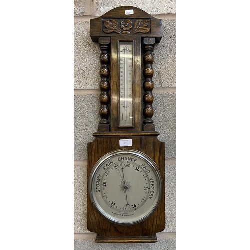 24 - An early/mid 20th century carved oak aneroid barometer - approx. 70cm high