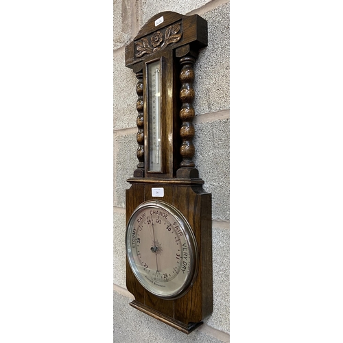 24 - An early/mid 20th century carved oak aneroid barometer - approx. 70cm high