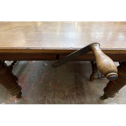 78 - A Victorian oak wind out extending dining table and eleven Cromwellian style oak and red vinyl chair... 