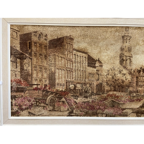 250 - A mid 20th century framed dyed fabric picture of a European scene - approx. 74cm high x 180cm wide