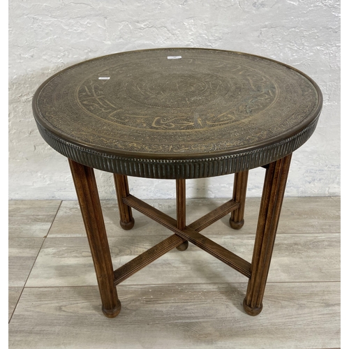 26 - An Indian Benares brass circular topped occasional table on wooden folding stand, registered design ... 