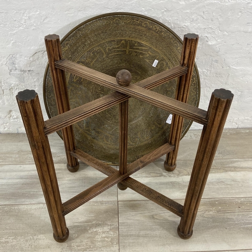 26 - An Indian Benares brass circular topped occasional table on wooden folding stand, registered design ... 