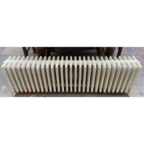 84 - A white painted cast iron radiator - approx. 47cm high x 150cm wide x 22cm deep