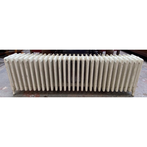 84 - A white painted cast iron radiator - approx. 47cm high x 150cm wide x 22cm deep