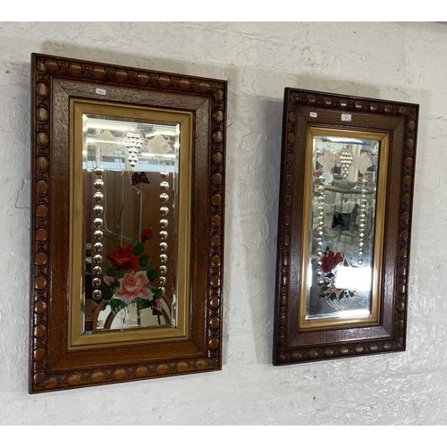 30 - A pair of Edwardian carved oak framed bevelled edge gypsy wall mirrors with butterfly and floral des... 