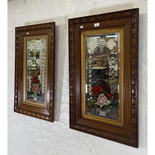 30 - A pair of Edwardian carved oak framed bevelled edge gypsy wall mirrors with butterfly and floral des... 