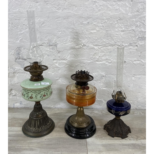 37 - Three Victorian cast metal and glass oil lamps, two Young's and one British Made - largest approx. 6... 