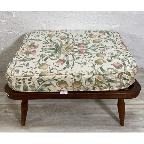 39 - An Ercol beech footstool with floral upholstered cushion - approx. 35cm high x 69cm wide x 52cm deep