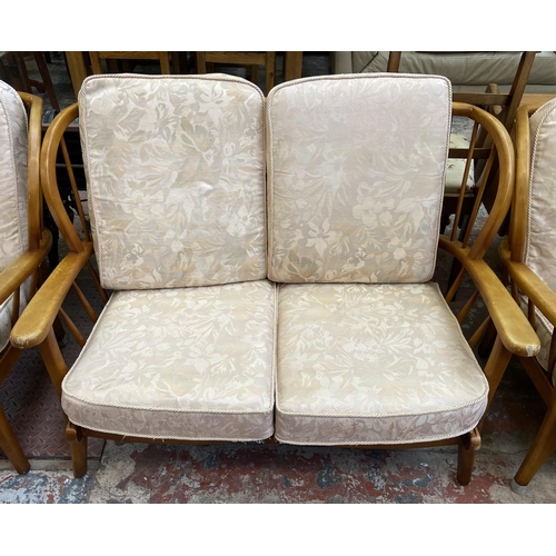 95 - A mid 20th century Ercol style beech four piece lounge suite comprising two seater sofa and three ar... 