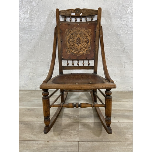 99 - An early 20th century beech rocking chair with embossed design