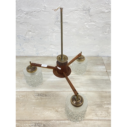 51 - A mid 20th century teak and brass three branch ceiling light fitting with glass shades - approx. 55c... 