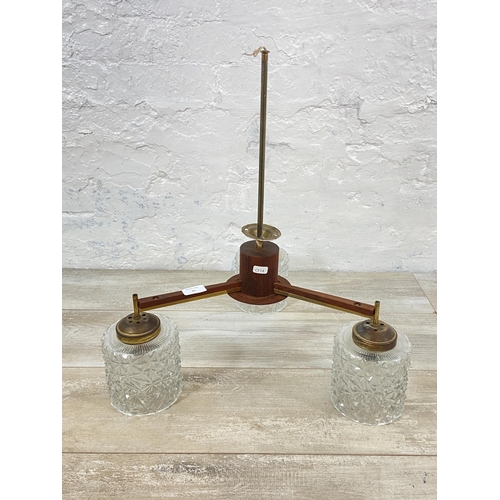 51 - A mid 20th century teak and brass three branch ceiling light fitting with glass shades - approx. 55c... 