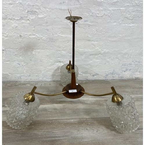 52 - A mid 20th century teak and brass three branch ceiling light fitting with glass shades - approx. 46c... 