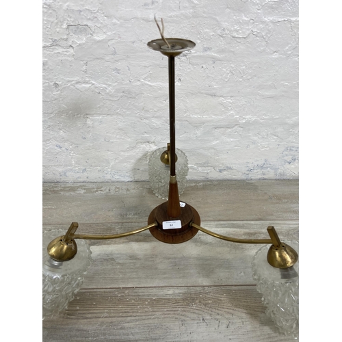 52 - A mid 20th century teak and brass three branch ceiling light fitting with glass shades - approx. 46c... 