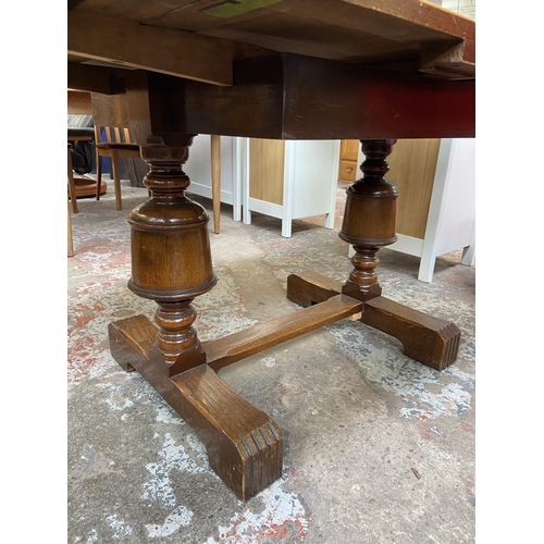 54 - A 1930s E. Gomme oak draw leaf dining table on baluster supports - approx. 74cm high x 92cm wide x 9... 