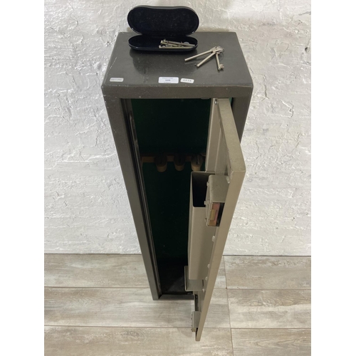 120 - A metal gun cabinet - approx. 132cm high x 29cm wide x 24cm deep (key in office)