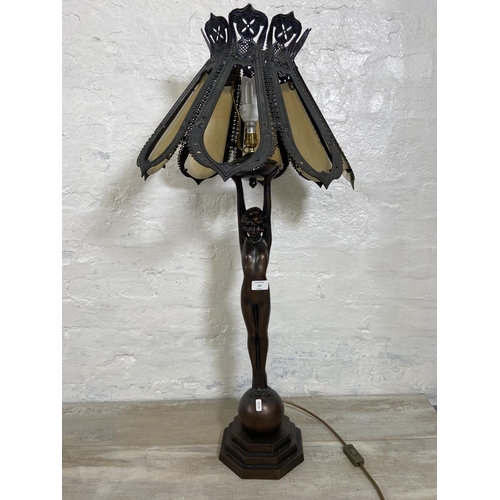 141 - An Art Deco style bronzed metal nude lady figural table lamp with cast metal and stained glass shade... 