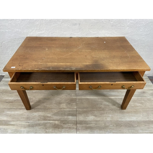 152 - An early/mid 20th century oak two drawer writing desk - approx. 79cm high x 152cm wide x 84cm deep