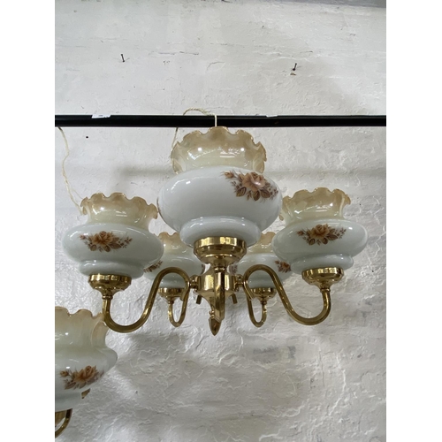 186 - A pair of brass five branch chandeliers with floral design opaque glass shades