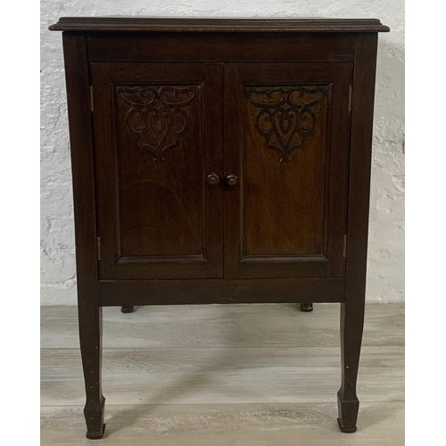 194 - An early 20th century carved mahogany two door music cabinet - approx. 72cm high x 50cm wide x 50cm ... 