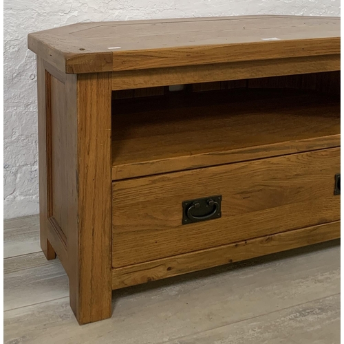 204 - A modern oak TV stand - approx. 56cm high x 102cm wide x 51cm deep