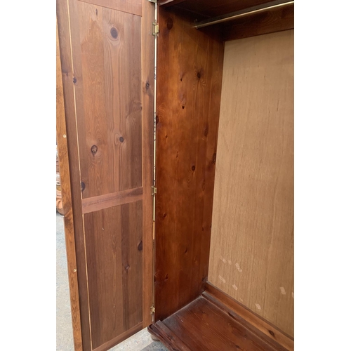 205 - A modern stained pine double wardrobe - approx. 180cm high x 95cm wide x 50cm deep