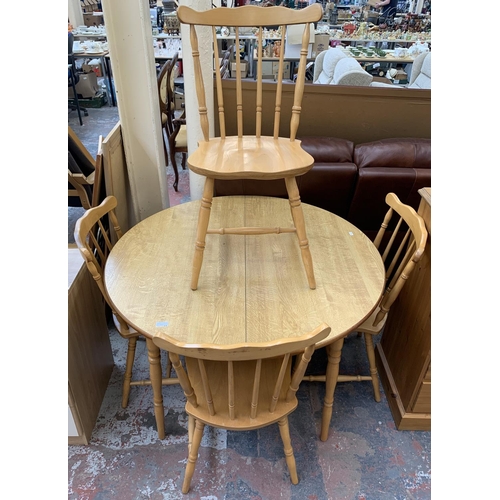 219 - A beech and oak effect circular extending dining table and four chairs - approx. 72cm high x 110cm d... 