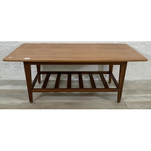 228 - A mid 20th century teak coffee table with magazine rack - approx. 44cm high x 48cm wide x 106cm long