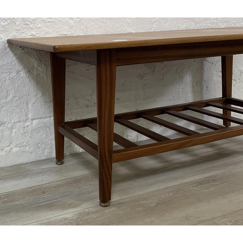 228 - A mid 20th century teak coffee table with magazine rack - approx. 44cm high x 48cm wide x 106cm long