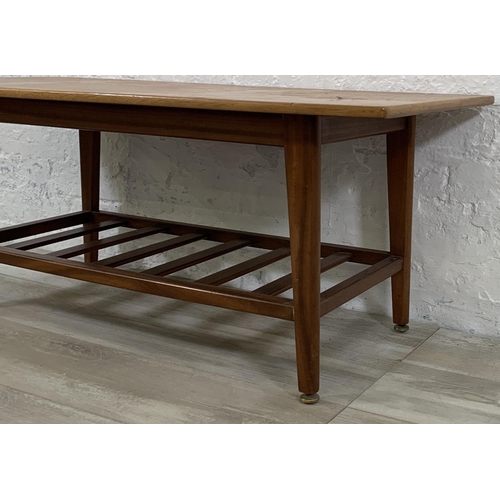 228 - A mid 20th century teak coffee table with magazine rack - approx. 44cm high x 48cm wide x 106cm long