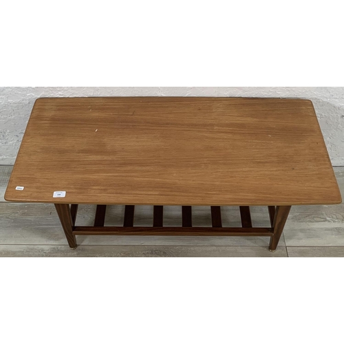 228 - A mid 20th century teak coffee table with magazine rack - approx. 44cm high x 48cm wide x 106cm long