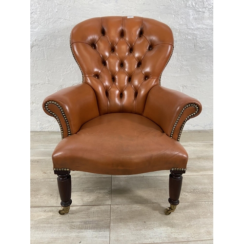 241 - A Victorian style tan leather Chesterfield armchair on turned mahogany supports and brass castors - ... 