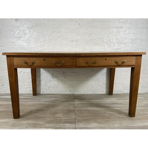 160 - An early/mid 20th century oak two drawer writing desk - approx. 79cm high x 152cm wide x 84cm deep