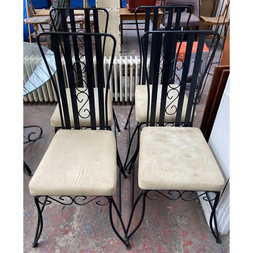 101 - Seven pieces of black painted wrought metal furniture, six dining chairs and one glass top circular ... 