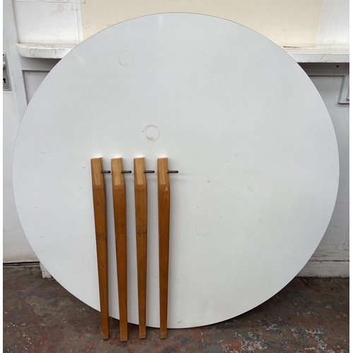 102 - A mid 20th century white laminate circular dining table on beech supports - approx. 123cm diameter