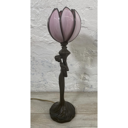 11 - An Art Nouveau style bronzed resin figural table lamp with pink stained and leaded glass tulip shape... 