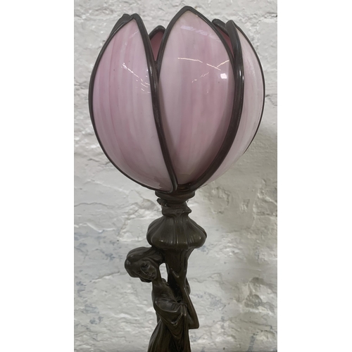 11 - An Art Nouveau style bronzed resin figural table lamp with pink stained and leaded glass tulip shape... 