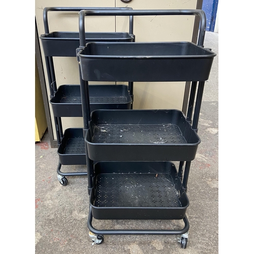 112 - A pair of black metal and plastic three tier storage trolleys - approx. 86cm high x 40cm wide x 30cm... 