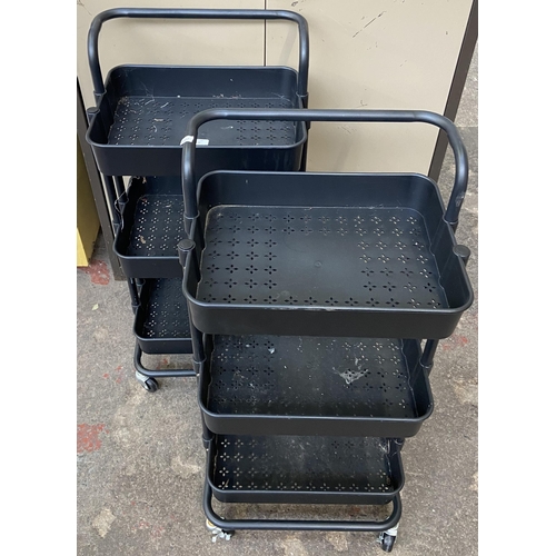 112 - A pair of black metal and plastic three tier storage trolleys - approx. 86cm high x 40cm wide x 30cm... 