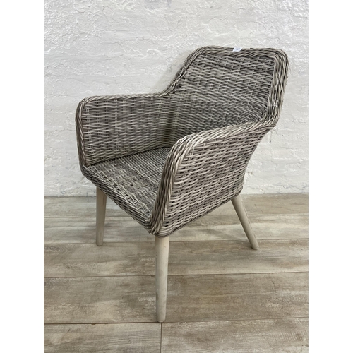 129 - A pair of plastic wicker effect garden armchairs on metal supports