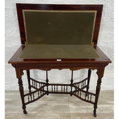 131 - A 19th century inlaid rosewood fold over games table with reeded supports and galleried stretcher - ... 