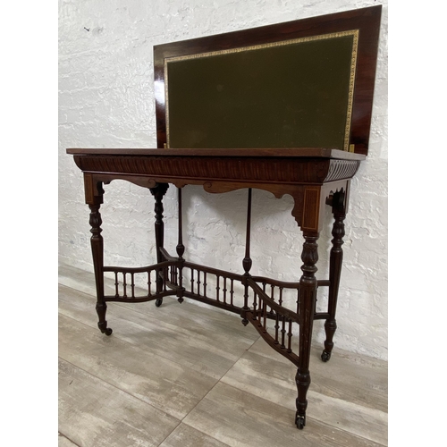 131 - A 19th century inlaid rosewood fold over games table with reeded supports and galleried stretcher - ... 