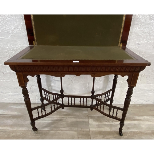 131 - A 19th century inlaid rosewood fold over games table with reeded supports and galleried stretcher - ... 