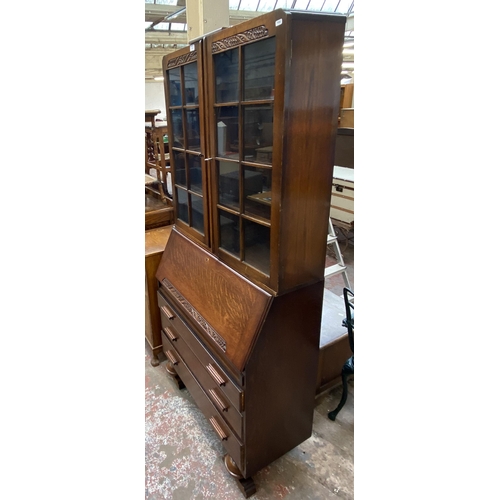 142 - An Art Deco carved oak bureau bookcase on baluster supports - approx. 198cm high x 91cm wide x 42cm ... 